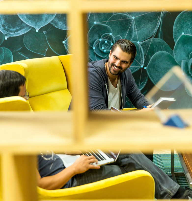Two people working together on a yellow couch